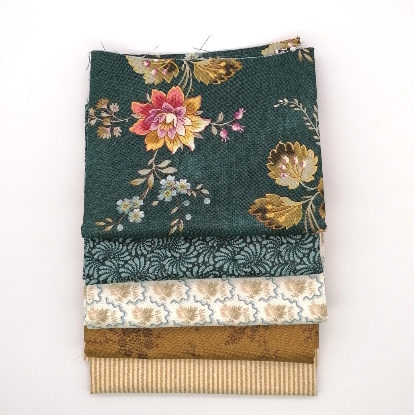 Fat Quarter Bundle LBQ18 - 5 fat quarters stacked showing deep forest green large floral, dark teal paisley, cream botanical, mustard gold tonal, and honey stripe from Laundry Basket Quilts