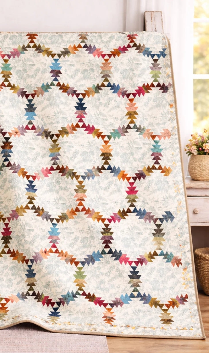 Colorful geometric patterned quilt on a wooden floor