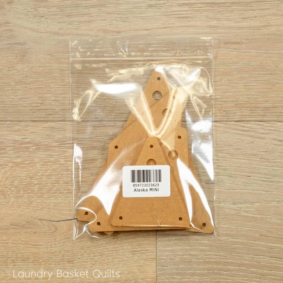 Acrylic templates for the mini alaska quilt in clear packaging on a wooden surface with 'Laundry Basket Quilts' branding.