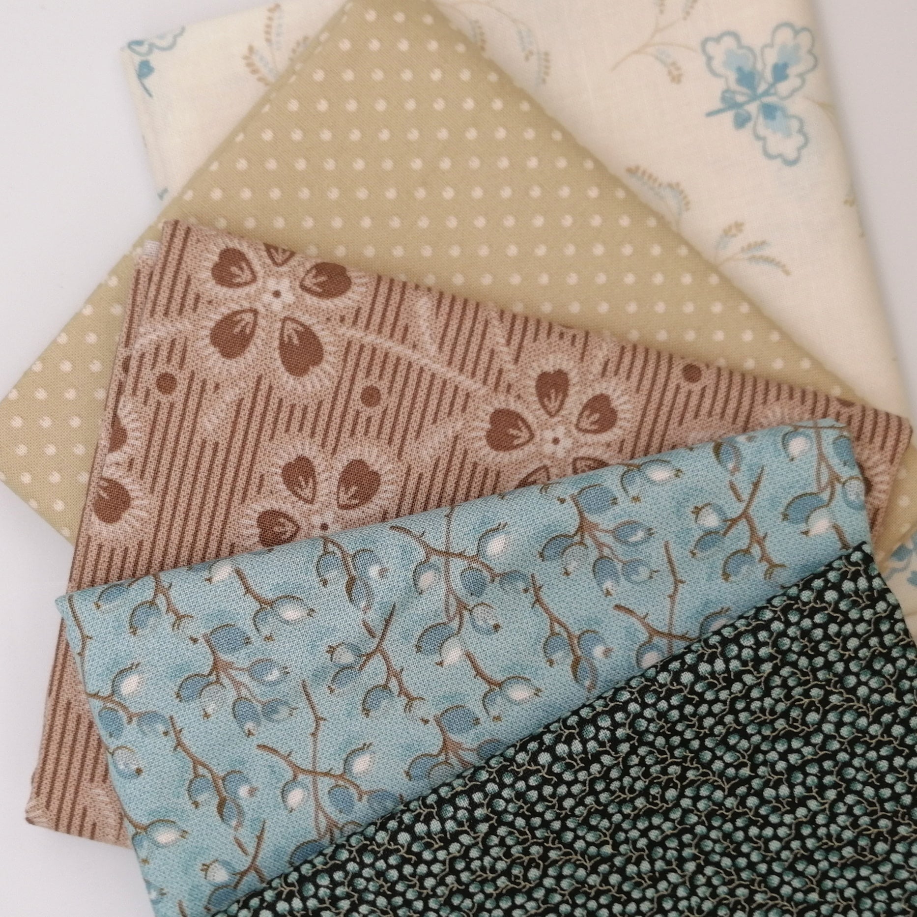 Fat Quarter Bundle LBQ16 - stacked fat quarters showing charcoal, blue berry, dusty rose, tan dot, and cream floral prints