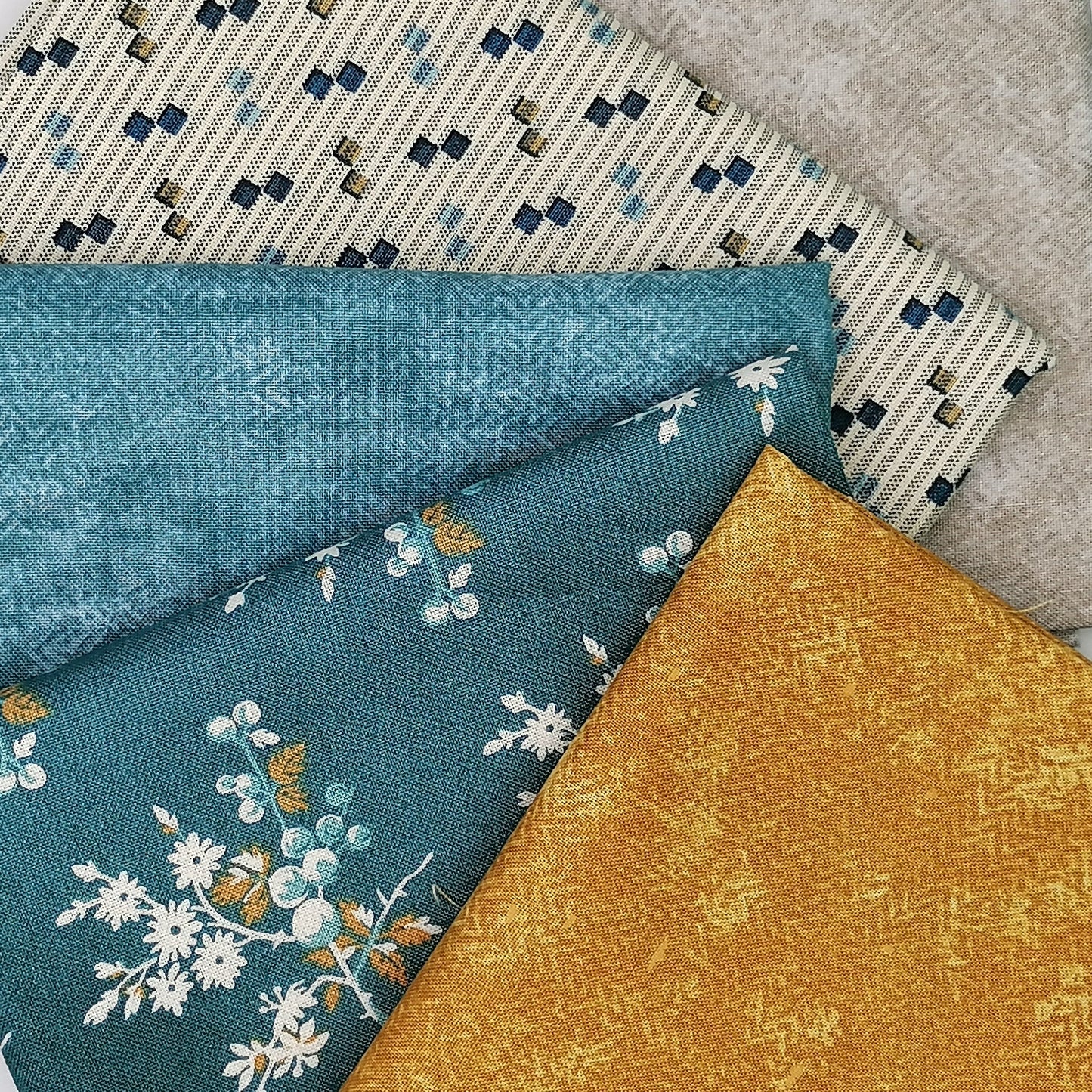 Fat Quarter Bundle LBQ17 - fanned flat lay showing teal floral, cream stripe, mustard gold and grey fat quarters