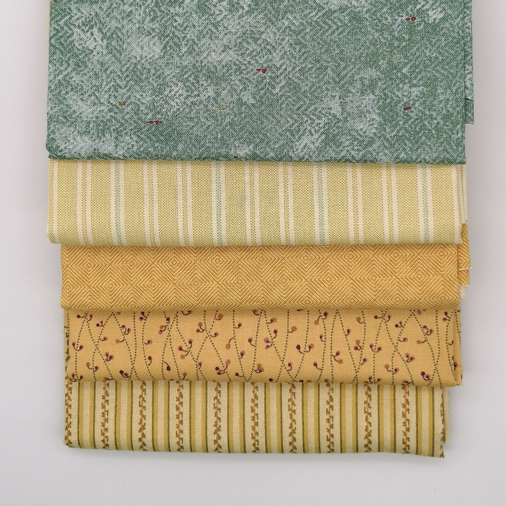 Fat Quarter Bundle LBQ20 - flat lay stack showing sage green, yellow stripe, mustard diamond, sand floral vine and cream stripe fat quarters from Laundry Basket Quilts for Andover Fabrics
