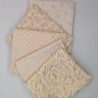 Fat Quarter Bundle LBQ21 - 5 fat quarters fanned showing cream botanical grasses, blush grid texture, blush hearts, blush ditsy floral branch, and cream letter envelope prints from Laundry Basket Quilts
