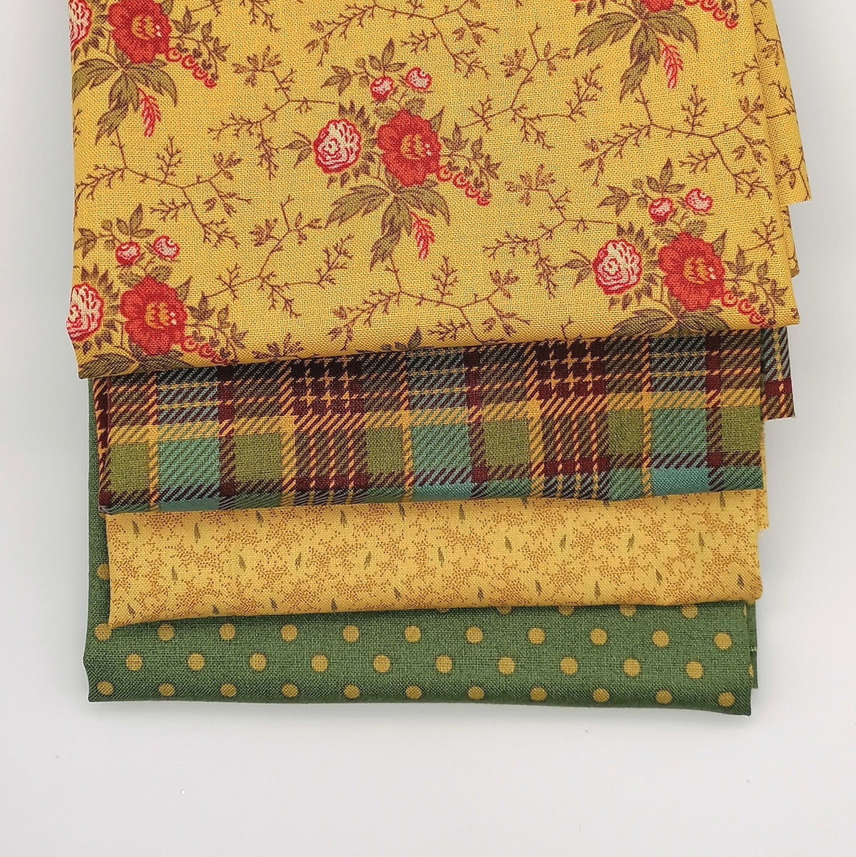 Fat Quarter Bundle LBQ24 - stacked flat lay showing golden floral vine, mustard teal tartan, sand tonal and sage green polka dot fat quarters from Laundry Basket Quilts for Andover Fabrics