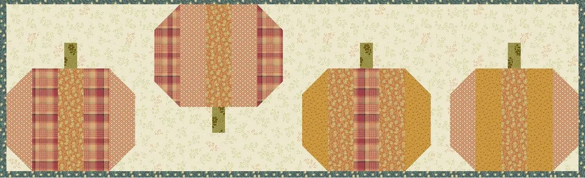 A quilted fabric wall hanging or banner featuring four stylized pumpkins arranged horizontally on a cream floral background with a green patterned border.