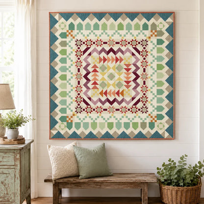 A large framed geometric quilt hanging on a white paneled wall above a rustic wooden bench with two pillows in a bright, styled room.